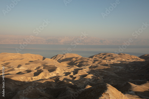 Beautiful landscape of Israeli Judean Desert mountains, with sunrise over the dry riverbed of Nahal Dragot Wadi, popular hiking trail winding between rugged rocky cliffs towards the Dead Sea. High photo