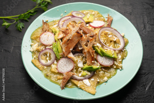 Green chilaquiles with pork meat and cheese. Mexican food