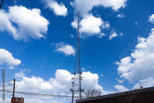  a tall gray radio tower surrounded by brown and bare winter trees with blue sky and clouds in Douglasville Georgia USA photo