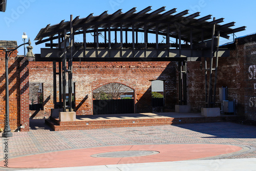 a performance stage made of red brick with a brown wooden pergola on top with tall black curved light posts in Douglasville Georgia USA photo