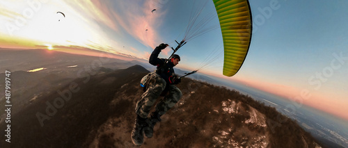 Man flying the paragliding at sunset photo