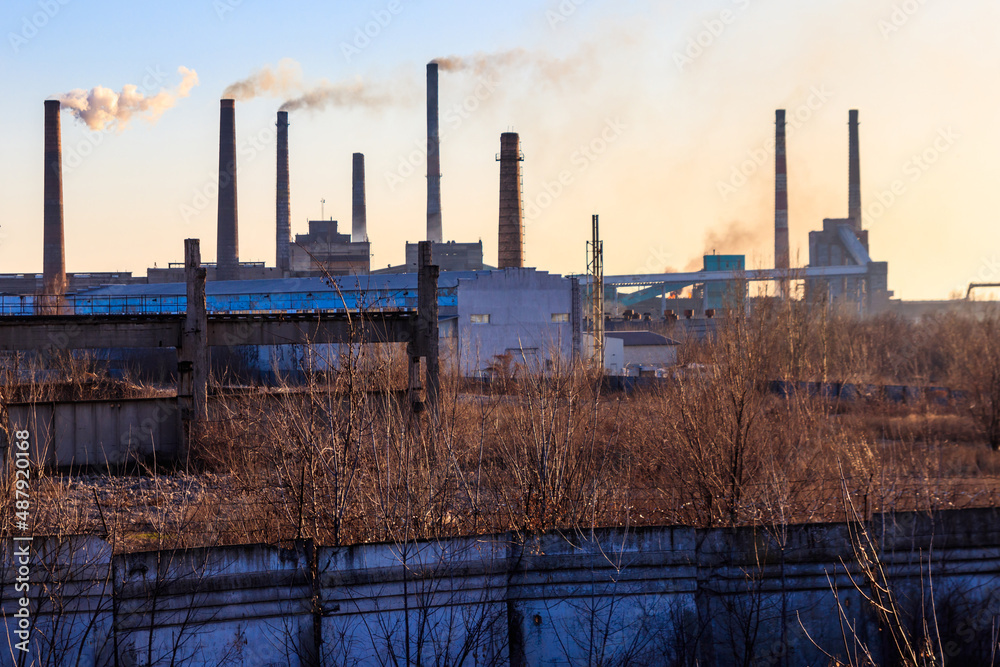 View of old factory with pipes with smoke. Air pollution, environmental damage