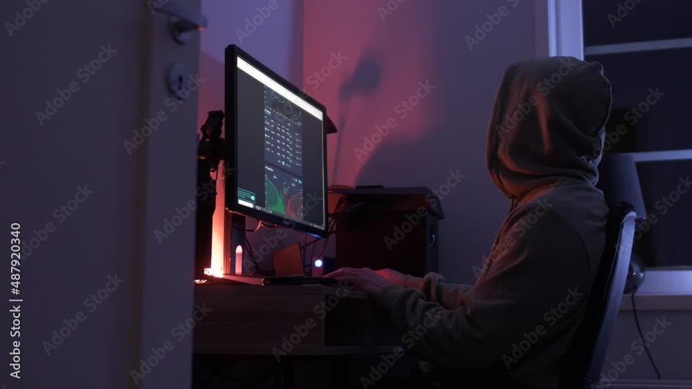 unrecognizable person sitting at computer looking at stocks at night unrecognizable person sitting at computer looking at stocks at night