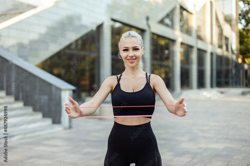 Fitness woman exercising with fitness rubber bands outdoors Fitness woman exercising with fitness rubber bands outdoors