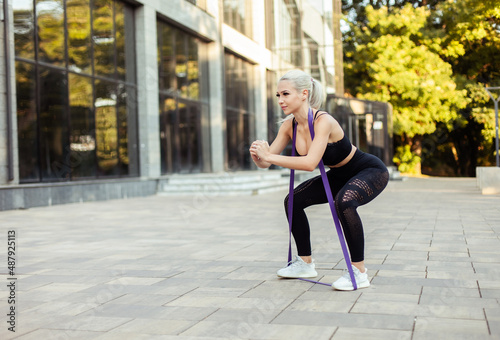 Fitness woman exercising with fitness rubber bands outdoors