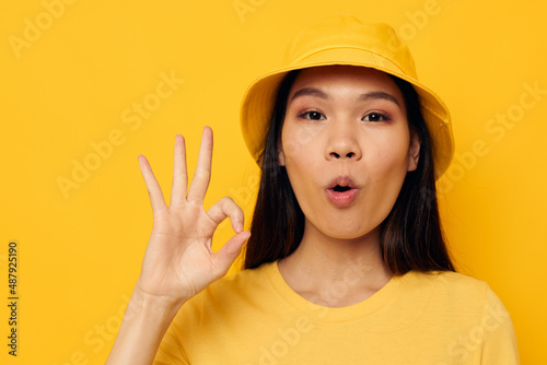 woman in a yellow t-shirt and hat posing emotions isolated background unaltered © Tatiana
