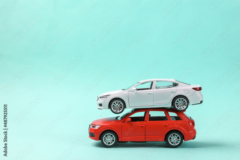 Fototapeta premium Two toy car models on a blue background
