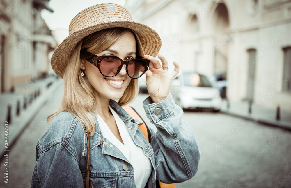 Street fashion, young stylish cheerful tourist woman in sunglasses and hat in the city Street fashion, young stylish cheerful tourist woman in sunglasses and hat in the city