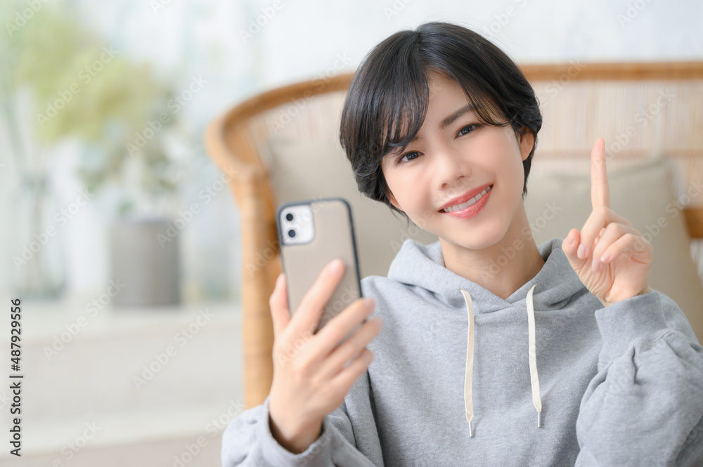 スマホを持って指差しをする女性 スマホを持って指差しをする女性