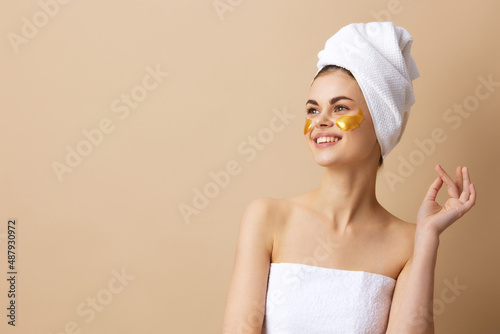 pretty woman golden patches on the face with a towel on the head close-up Lifestyle