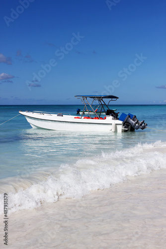 White boat in the open sea against a blue sky with white clouds on the horizon