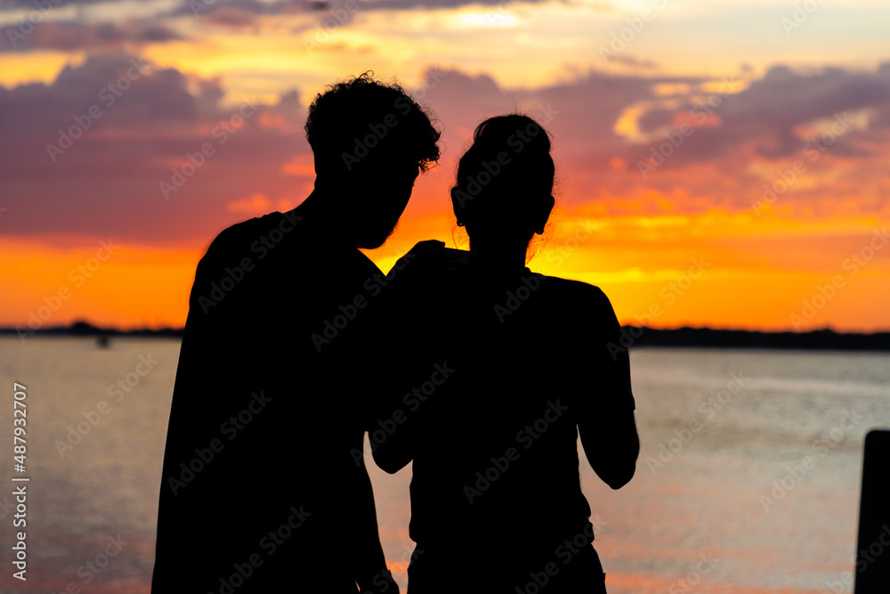 Couple looking at sunset over lake