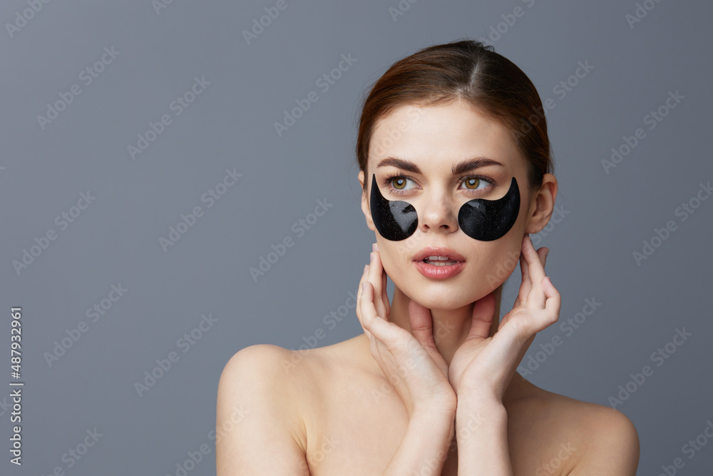 pretty woman eye patches on face bare shoulders skin care close-up Lifestyle pretty woman eye patches on face bare shoulders skin care close-up Lifestyle