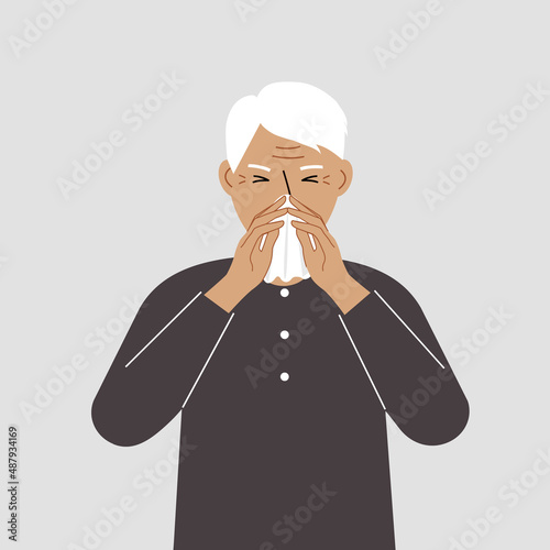 A grandfather covers his nose with his hands with a handkerchief. The concept of a sick person, sneezing, seasonal allergies, bad smell.