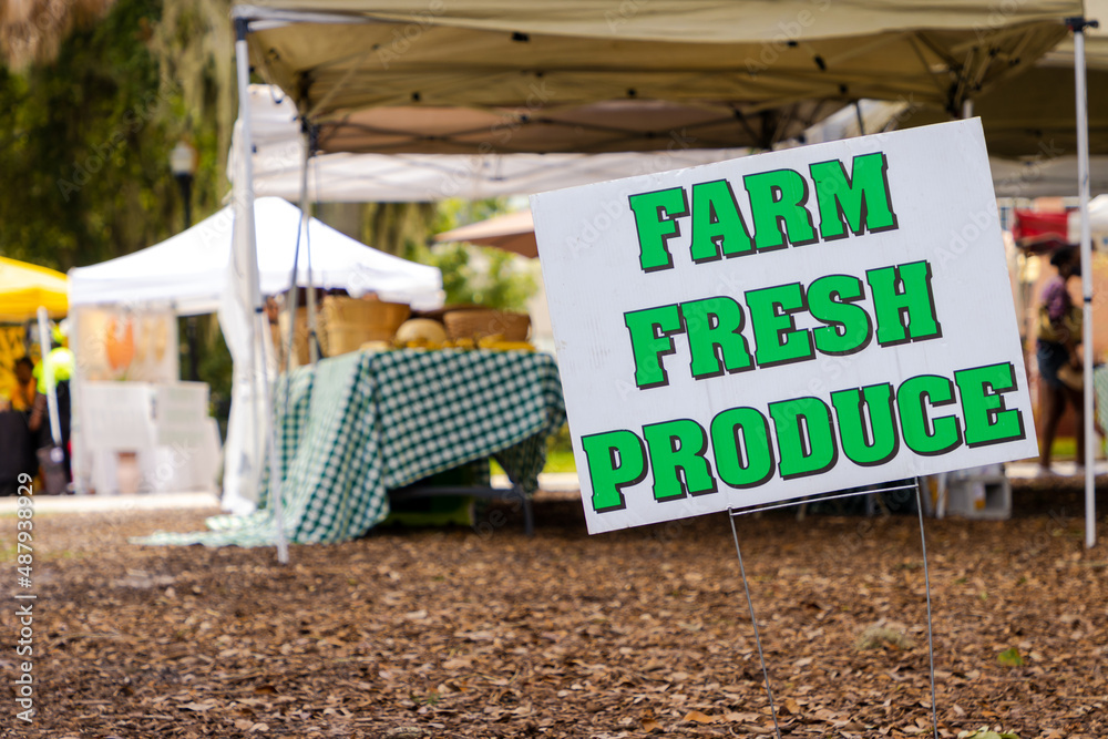 Fototapeta premium Sign advertising a farmer's market in a downtown public park