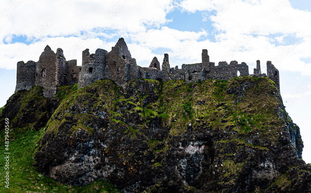Ruin of the old  Dunluce castle in Northern Ireland, United Kingdom nearby Bushmills. Remains of a medieval castel or historical fortress built with stones on top of a cliff in county Antrim. Ireland