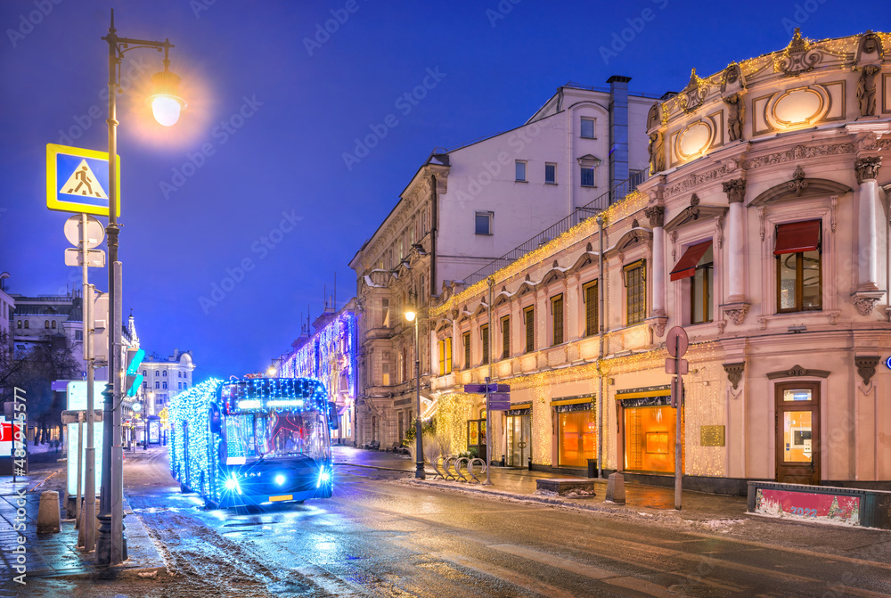 Fototapeta premium New Year's bus on Petrovka street in Moscow in the light of night lights