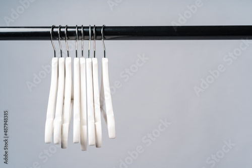 Metal rack with clothes hangers on grey background