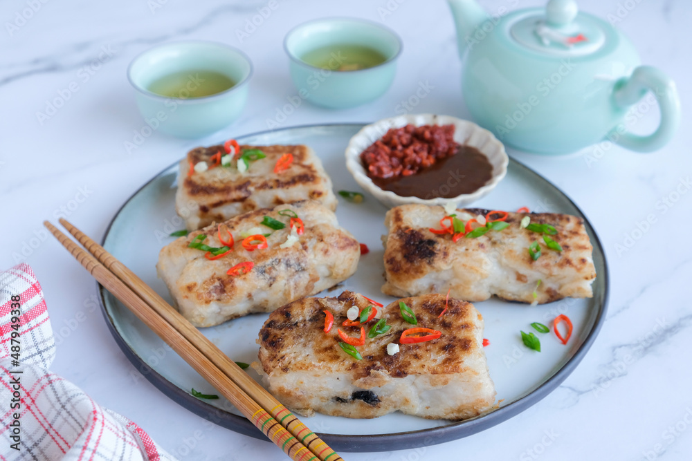 Popular Chinese New Year food. Turnip Cake aka Lo Bak Go. Actually made from radish and rice flour. For own consumption, you can add ground pork, diced Chinese sausage and mushroom and pan fried.