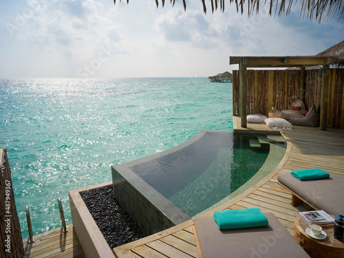 Fototapeta Naklejka Na Ścianę i Meble -  Beautiful Outdoor Pool Deck View Sunrise Overwater Pool Villa at InterContinental Maldives.