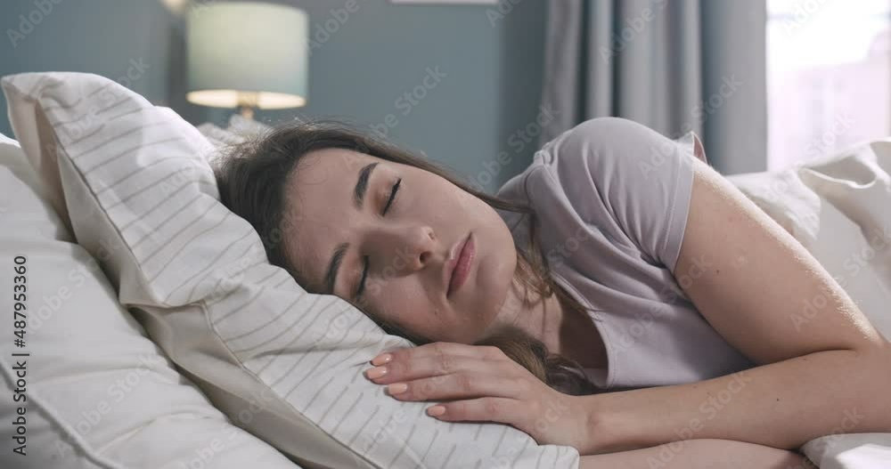Portrait of calm young woman sleeping well in comfortable cozy bed on soft pillow. Caucasian female resting, enjoying healthy good sleep nap in the morning. Portrait of calm young woman sleeping well in comfortable cozy bed on soft pillow. Caucasian female resting, enjoying healthy good sleep nap in the morning.