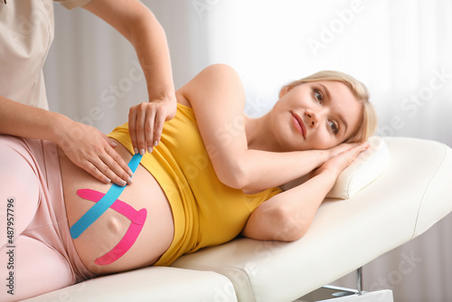 Physiotherapist applying ki...