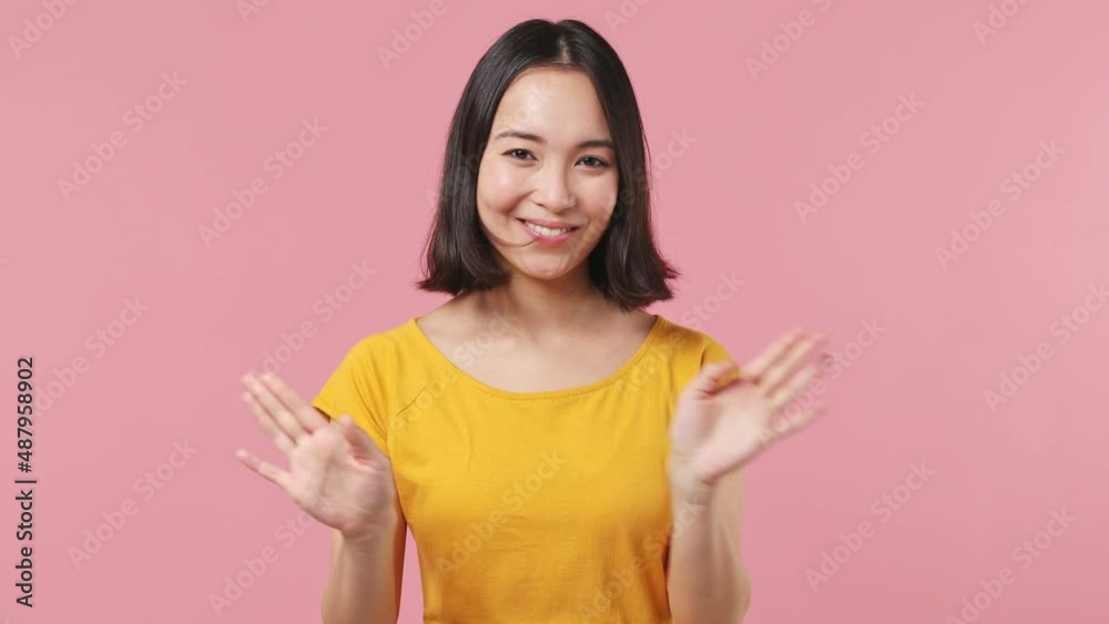 Sad young woman of Asian ethnicity 20s wears yellow t-shirt look camera point fingers herself ask say who me no thanks i do not need it isolated on plain pastel light pink background studio portrait Sad young woman of Asian ethnicity 20s wears yellow t-shirt look camera point fingers herself ask say who me no thanks i do not need it isolated on plain pastel light pink background studio portrait