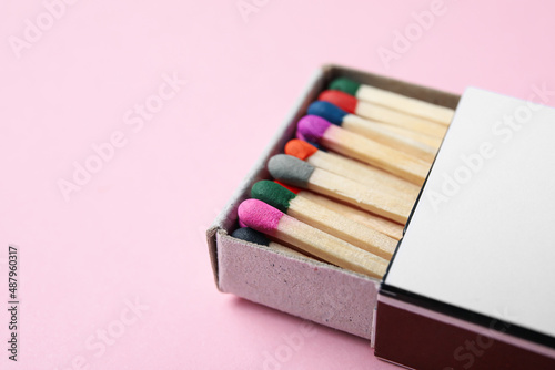 Box with new matchsticks on pink background, closeup