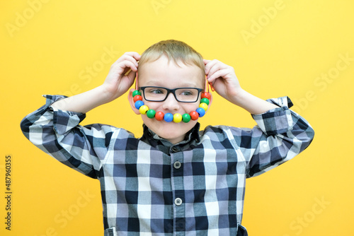 development of fine motor skills. Toddler boy is stringing beads on a string. happy child. smile beads