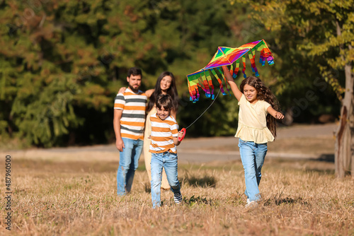 Happy little boy and his sister with kite running outdoors
