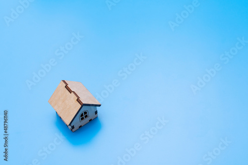 small toy wooden house on a blue background
