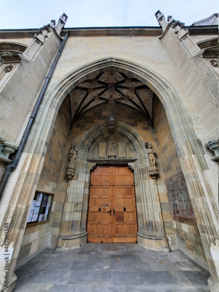 old wooden brown door with a vault at the entrance to the church