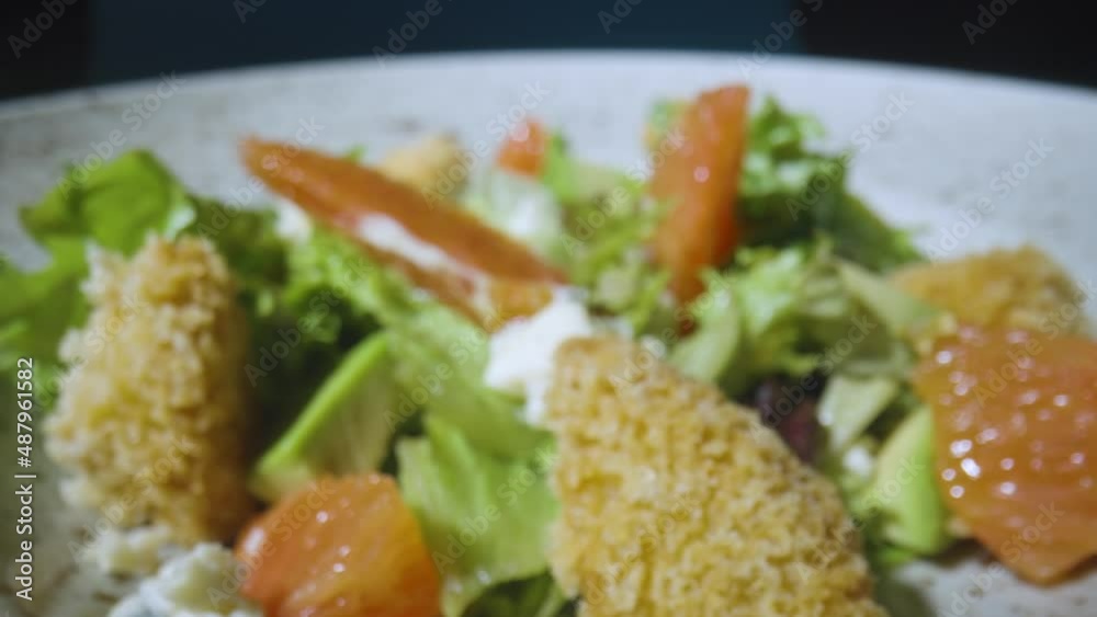 Salad with grapefruit, green lettuce, avocado, tuna and cheese on gray plate close up. Restaurant food, healthy dish. Italian salad. French cuisine. Camera zoom in slow motion. Salad with grapefruit, green lettuce, avocado, tuna and cheese on gray plate close up. Restaurant food, healthy dish. Italian salad. French cuisine. Camera zoom in slow motion.