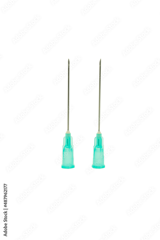 Vertical photo with a pure white background of a medical syringe needle with a light green base and a dark metal needle in an upright position. Vertical photo with a pure white background of a medical syringe needle with a light green base and a dark metal needle in an upright position.