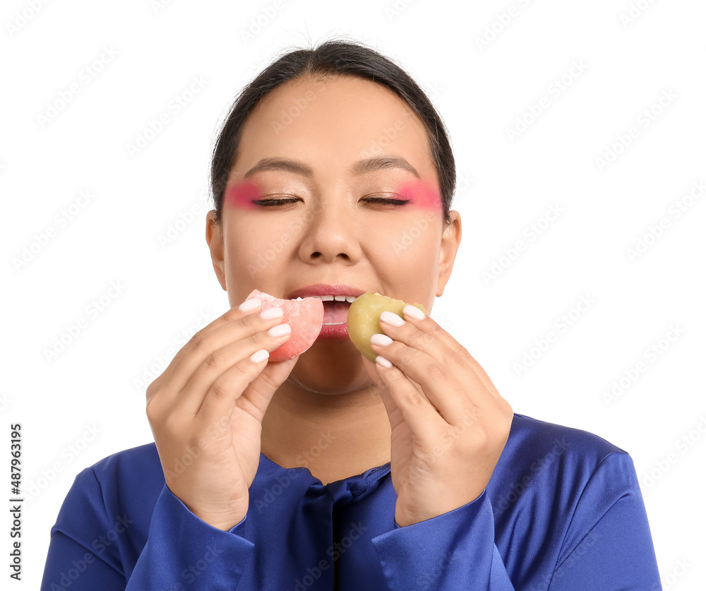 Beautiful Asian woman eating tasty Japanese mochi on white background