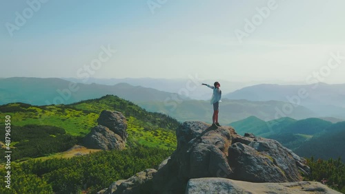 Tourist woman stands on a rock with arms raised, at an altitude of 1700m. Beautiful landscape of the Ukrainian Carpathians. Sunrise in the mountains, morning in the mountains photo