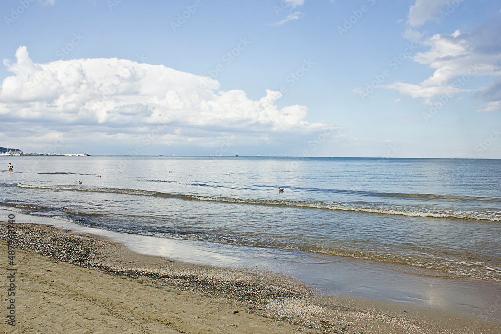 seascape. sandy seashore, sea and cloudy sky