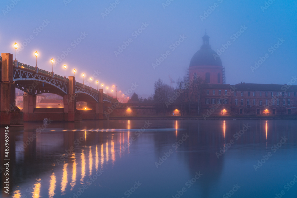 Garonne river and Dome of the 'Hopital de la Grave' at sunrise in fog in Toulouse, France