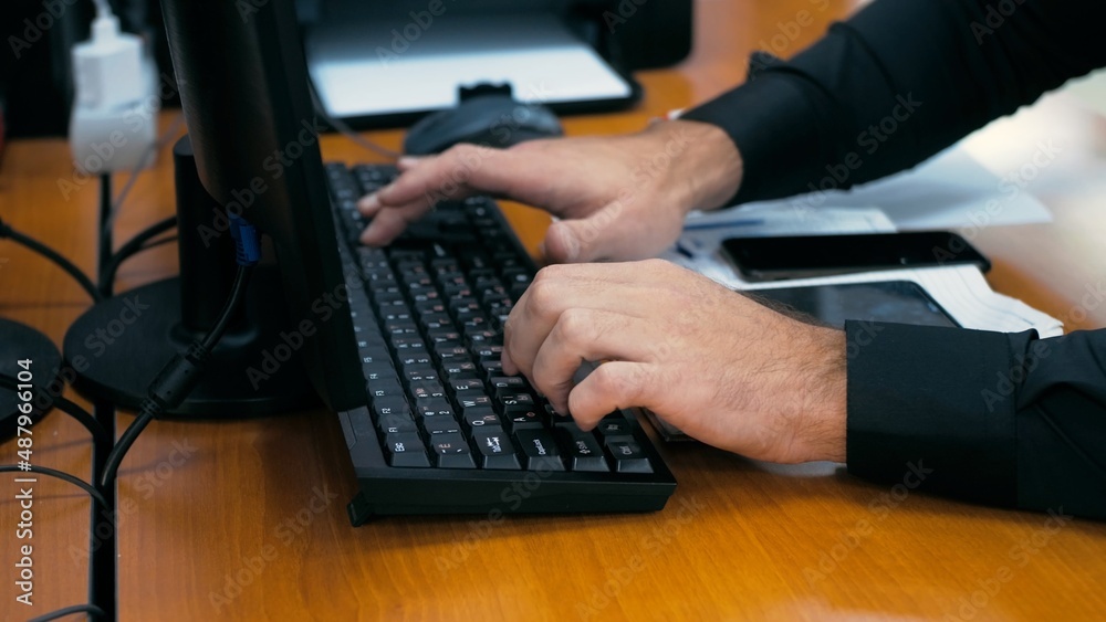 Office worker during work. Man fills out a statement on the keyboard. Office worker during work. Man fills out a statement on the keyboard.