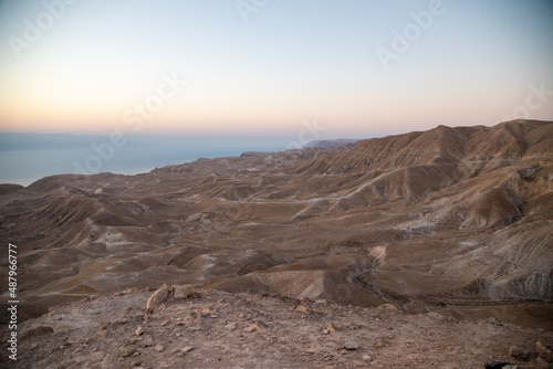 Beautiful landscape of Israeli Judean Desert mountains, with sunrise over the dry riverbed of Nahal Dragot Wadi, popular hiking trail winding between rugged rocky cliffs towards the Dead Sea. High photo