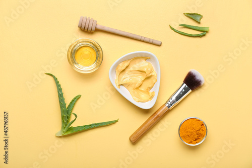 Bowl with turmeric mask, powder and honey on beige background