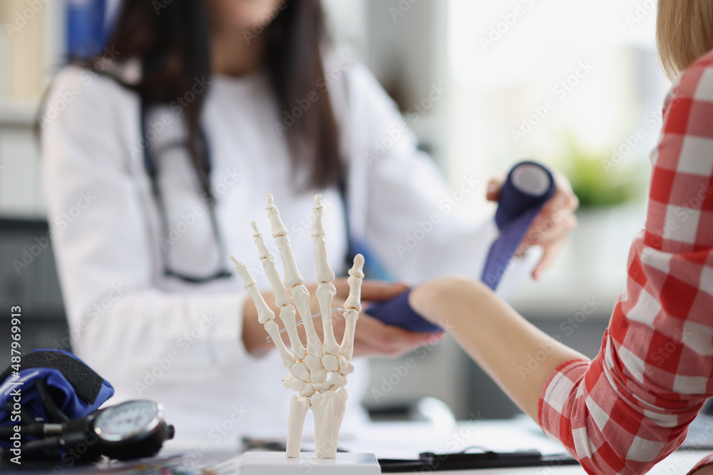 The doctor makes a bandage on the woman's wrist, blurry The doctor makes a bandage on the woman's wrist, blurry