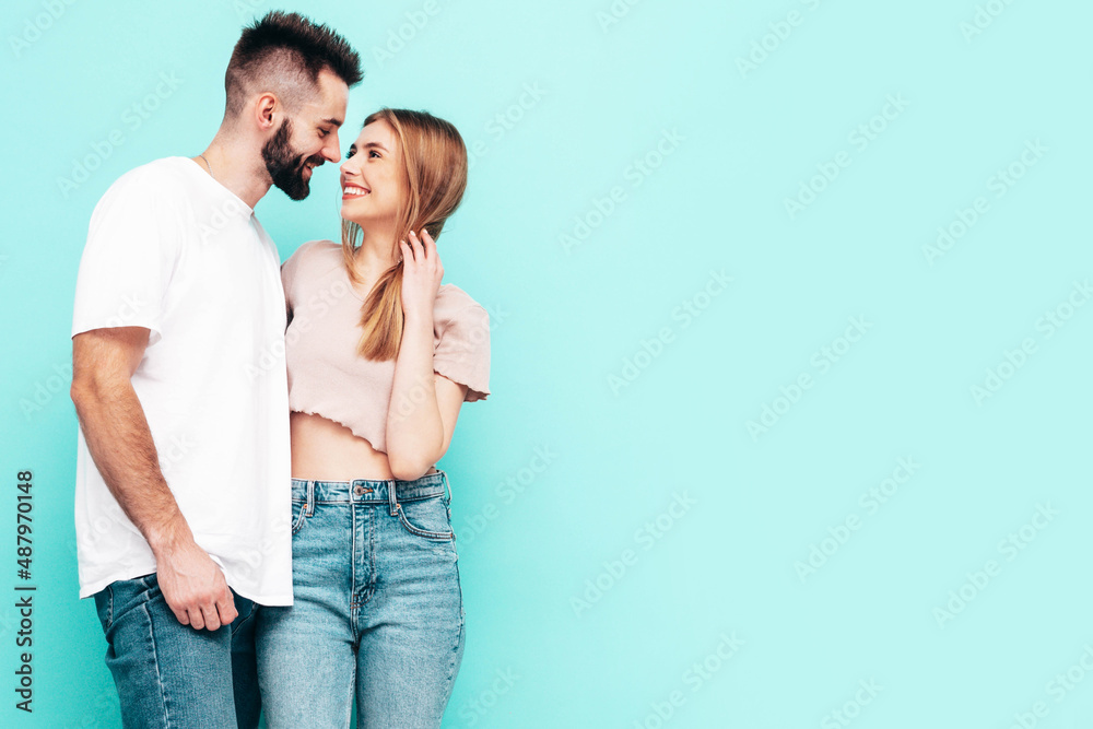 Sexy smiling beautiful woman and her handsome boyfriend. Happy cheerful family having tender moments near blue wall in studio.Pure cheerful models hugging.Embracing each other. Cheerful and happy