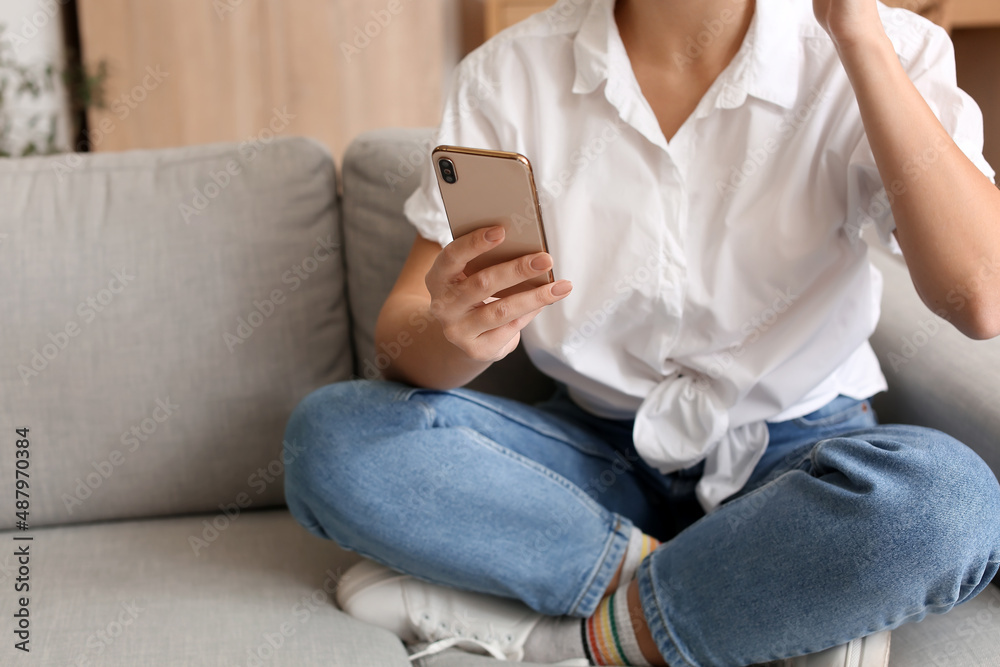Pretty young woman using mobile phone at home Pretty young woman using mobile phone at home