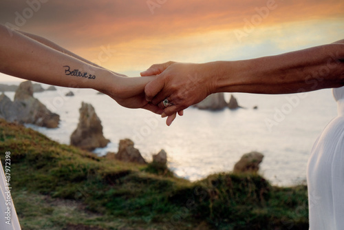 Fototapeta Naklejka Na Ścianę i Meble -  two people holding hands on beach
