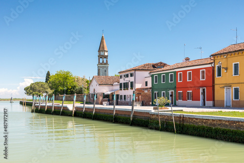 Bunte Häuser mit einem Turm an der Lagune auf der Insel Burano bei Venedig