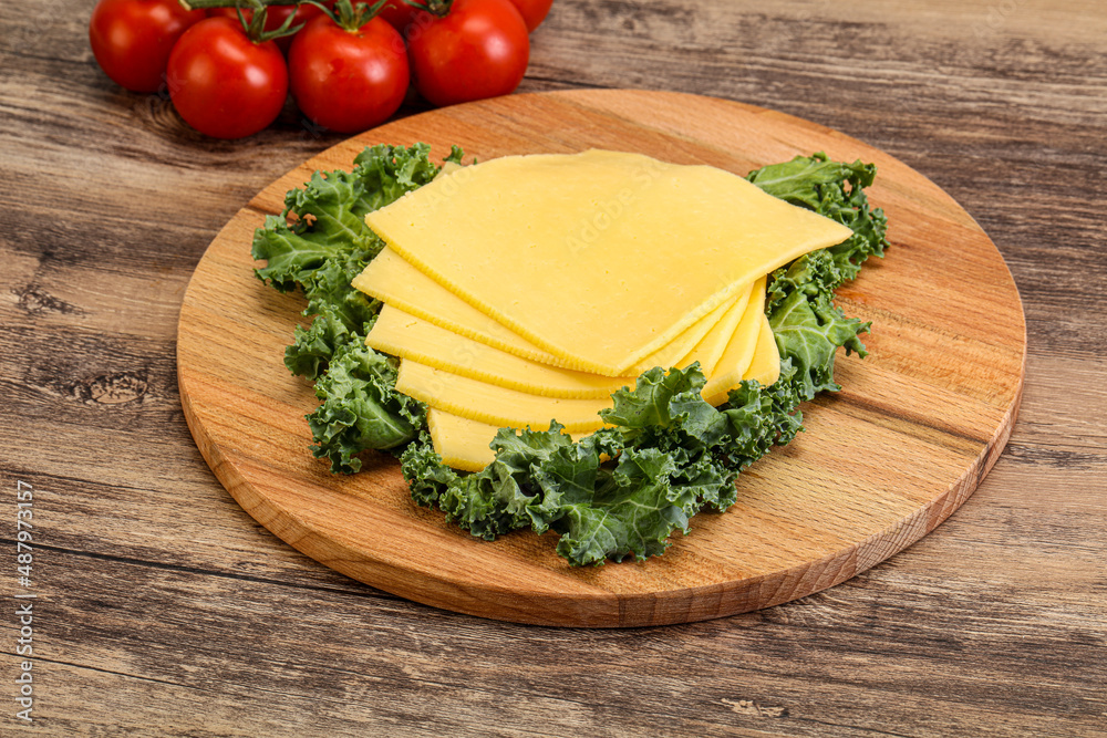 Sliced Gauda cheese over board Sliced Gauda cheese over board