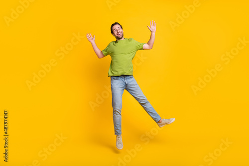 Full length photo of young man good mood jumper wear casual clothes isolated over yellow color background