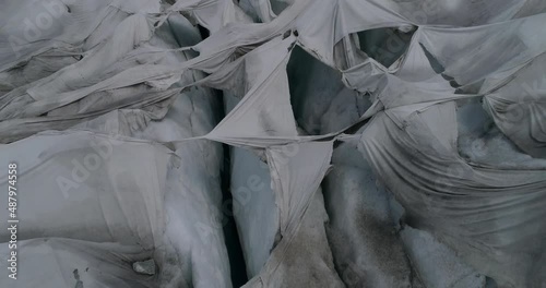 Ripped tarps over glacier ice formations, Rhone Glacier, Swiss Alps
