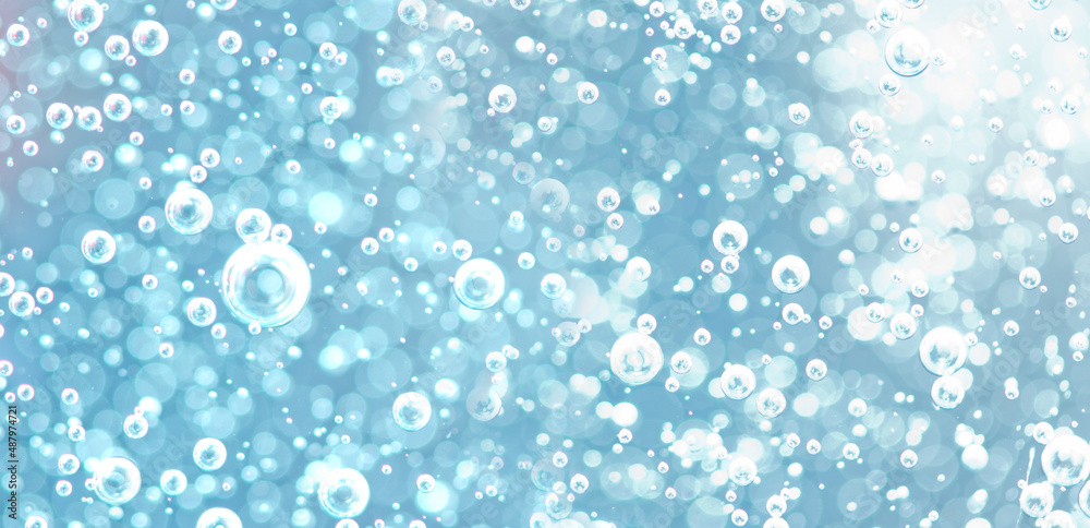 Air bubbles underwater in bright light. Background image of oxygen bubbles in light blue tones with bokeh Air bubbles underwater in bright light. Background image of oxygen bubbles in light blue tones with bokeh
